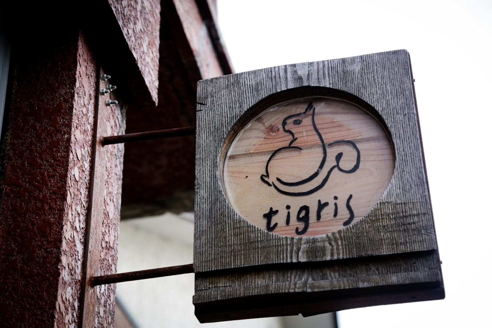 リスのイラストが描かれた tigris の木の看板